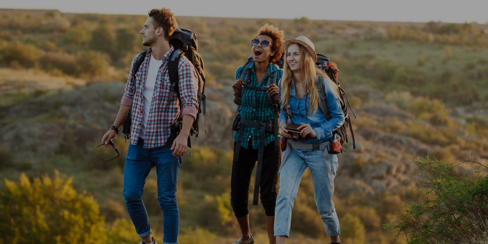 Three people hiking in a natural landscape with backpacks